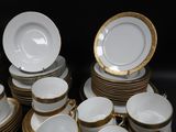 many white and gold plates and bowls on the table