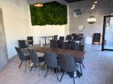 tables and chairs in a room with a mossy wall on the wall