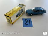 une petite voiture bleue en plastique à côté d'une boîte remplie de chiffres