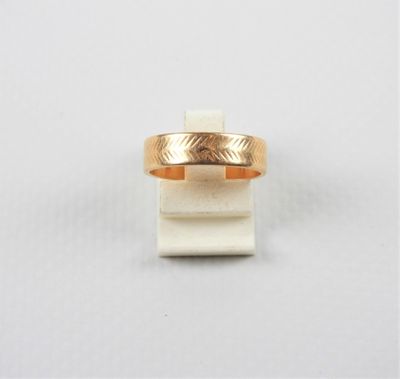 a close up of a gold ring on a white surface