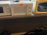 two microwaves and a coffee maker on the counter