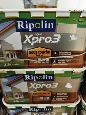 trois seaux de peinture empilés les uns sur les autres dans un magasin