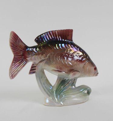 a glass figurine of a fish that is sitting on a stand
