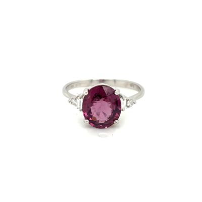 a close up of a pink sapphire and diamond ring on a white background