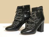 une paire de bottines noires ornées de chaînes