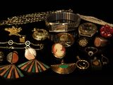 many different types of jewelry on a black surface