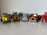 Plusieurs camions miniatures sont alignés en rang sur une table