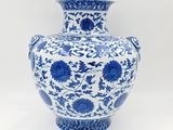 un vase bleu et blanc posé sur une surface blanche