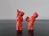 two small figurines of people standing on a table