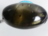 someone is holding a spoon with a brown and blue substance on it