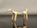 une petite figurine représentant un chien posée sur une surface noire
