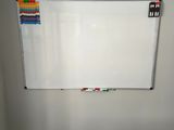 a white board on the wall in the corner of a room