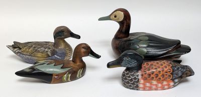 three ducks sitting on top of each other on a white surface