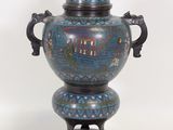 un vase bleu surmonté d'une statuette