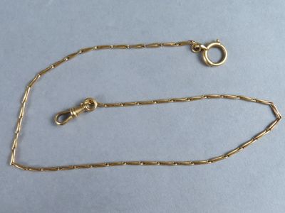 a close up of a gold chain with a clasp on a blue surface