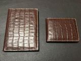 deux portefeuilles en cuir marron posés sur une table noire