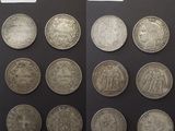 Plusieurs types de pièces d'argent sont exposés sur un fond noir