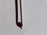 a metal object with a wooden handle on a white surface