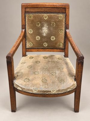 une vieille chaise en bois dont l'assise est recouverte d'un tissu à motifs floraux