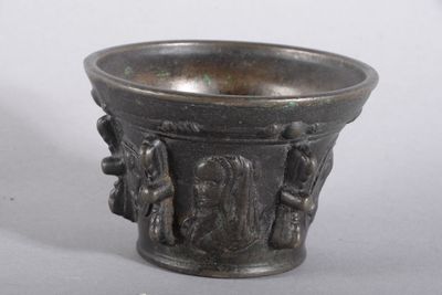 une tasse en métal décorée d'un motif, posée sur une table