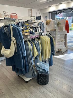 un portemanteau dans un magasin de vêtements, sur lequel sont suspendus des vêtements