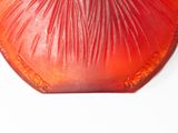 a red and orange object on a white surface