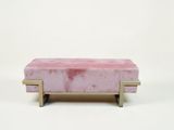 banquette en velours rose avec des pieds en laiton sur fond blanc