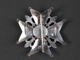 an image of a silver colored broochle on a black surface