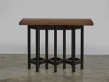 une table noire et en bois, à trois pieds, avec un plateau en bois