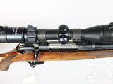 a close up of a rifle with a scope mounted on top of it