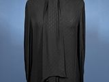 a black blouse on a mannequin dummy with a blue background
