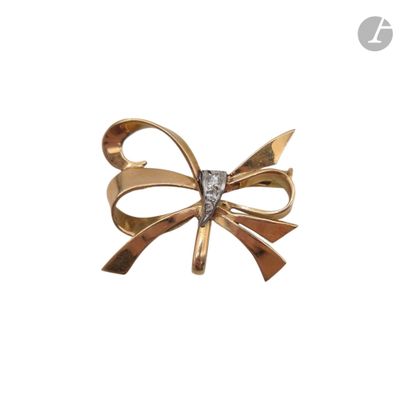 un gros plan sur une broche en forme de nœud, en or et diamants