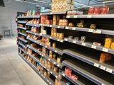 many shelves of food in a grocery store that are empty