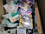 a cardboard box full of books and magazines on the floor