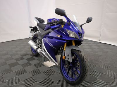 une photo d'une moto bleue garée dans une pièce