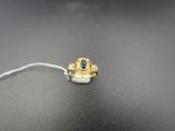 une bague en or sertie d'une pierre bleue repose sur une surface noire