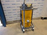 a yellow vacuum sitting on a cart in front of a wall