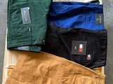 plusieurs paires de pantalons pour homme posées sur une caisse en bois