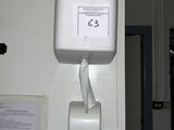 a white paper towel dispenser hanging on the wall
