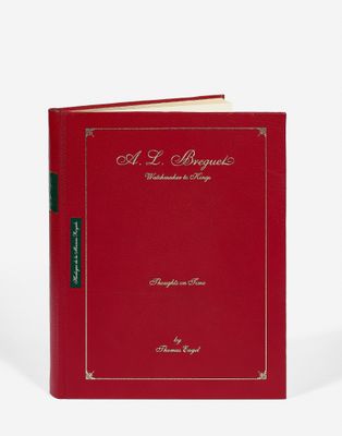 un livre avec une couverture rouge et des lettres dorées
