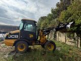 a picture of a backhoe that is parked in the grass