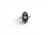 an antique diamond cluster ring with black and white diamonds