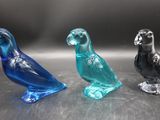 trois oiseaux en verre posés sur une table