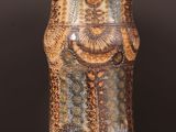a brown and blue vase sitting on a wooden table