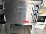 un four argenté installé dans une cuisine, à côté d'une cuisinière