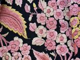 pink and yellow flowers on a black background with pink and yellow leaves