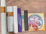 books and other items on a wooden table next to a roll of paper