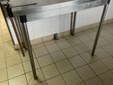 une table en métal sur laquelle est posé un couteau, dans une cuisine