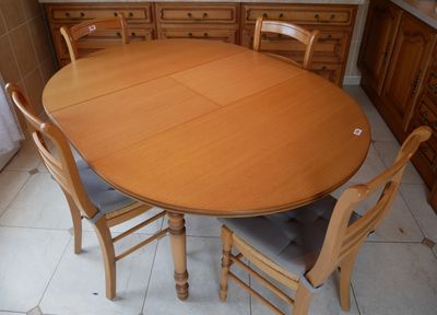 une table en bois entourée de quatre chaises dans la cuisine