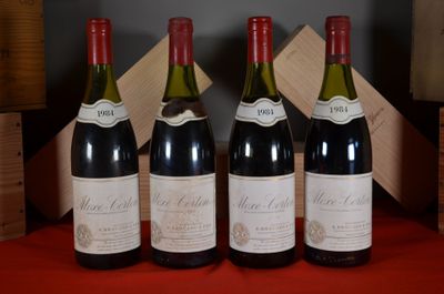 four bottles of wine are lined up on a red table
